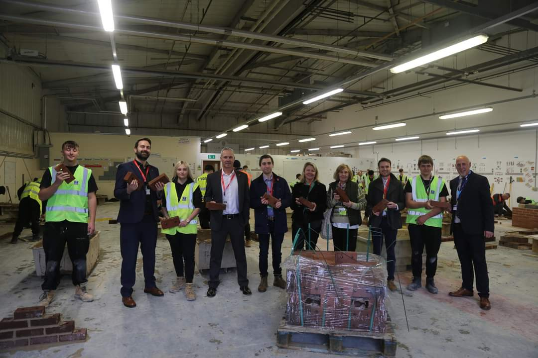 Ciaran and other individuals holding a brick